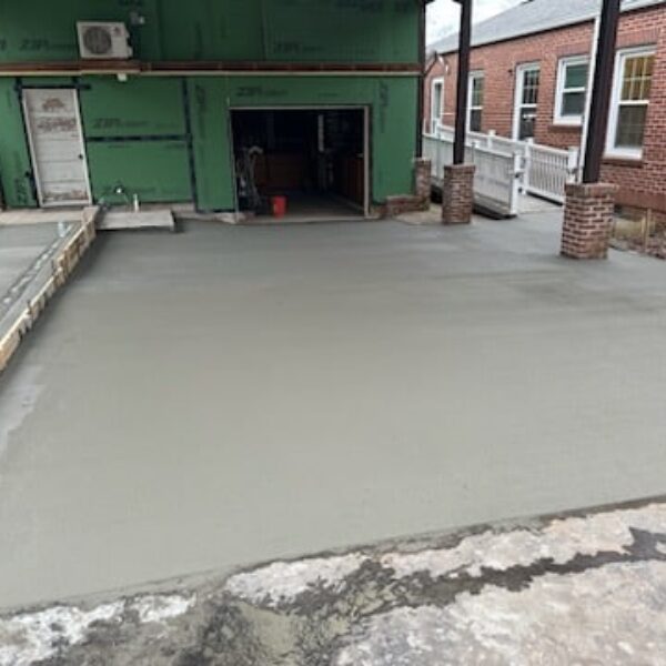 photo of freshly poured concrete around a brick building