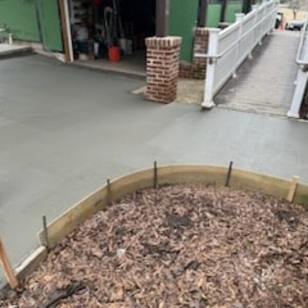 photo of freshly poured concrete around a brick building