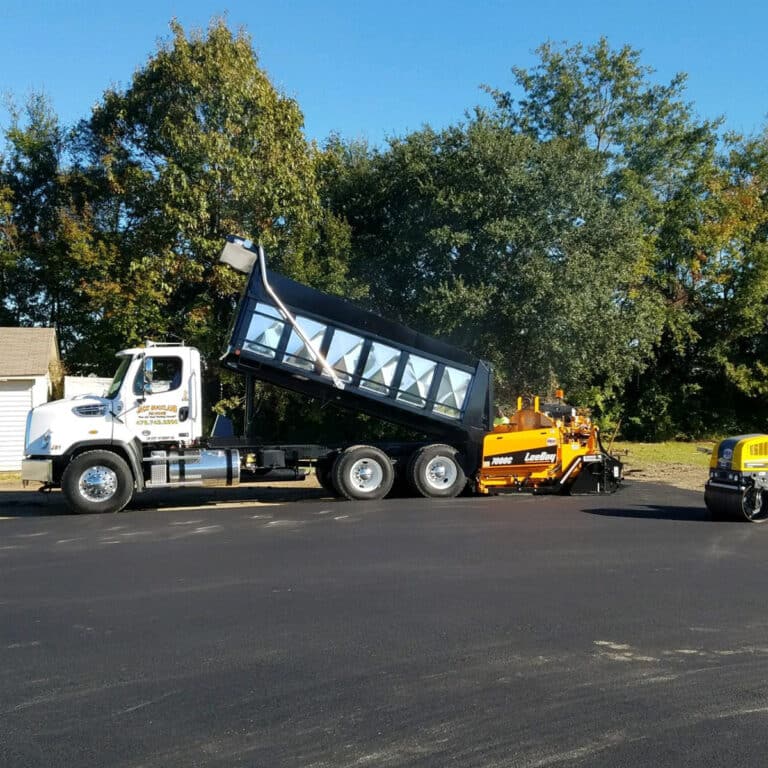 a Jack Buckland Paving truck loading up a paving roller machine