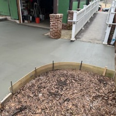 photo of freshly poured concrete around a brick building